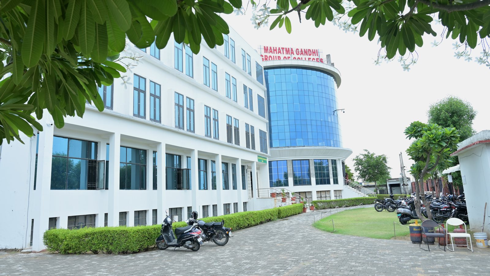 Tree-framed healthcare campus building at MGGC Sikar photographed in July 2026