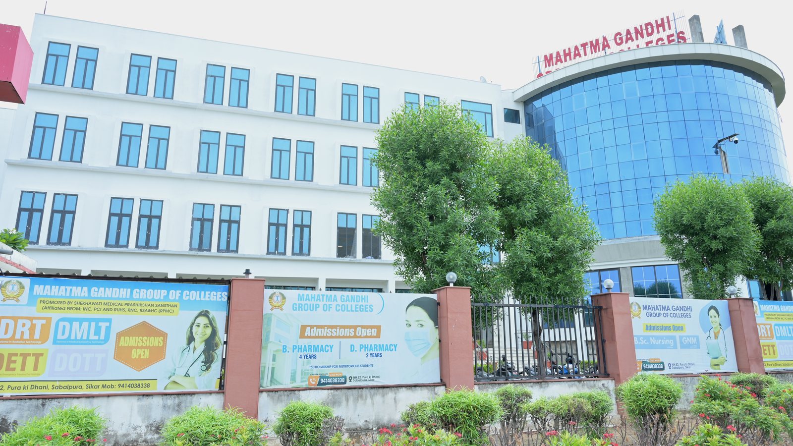 B.Pharm and D.Pharm admission banners outside MGGC Sikar pharmacy campus, July 2026